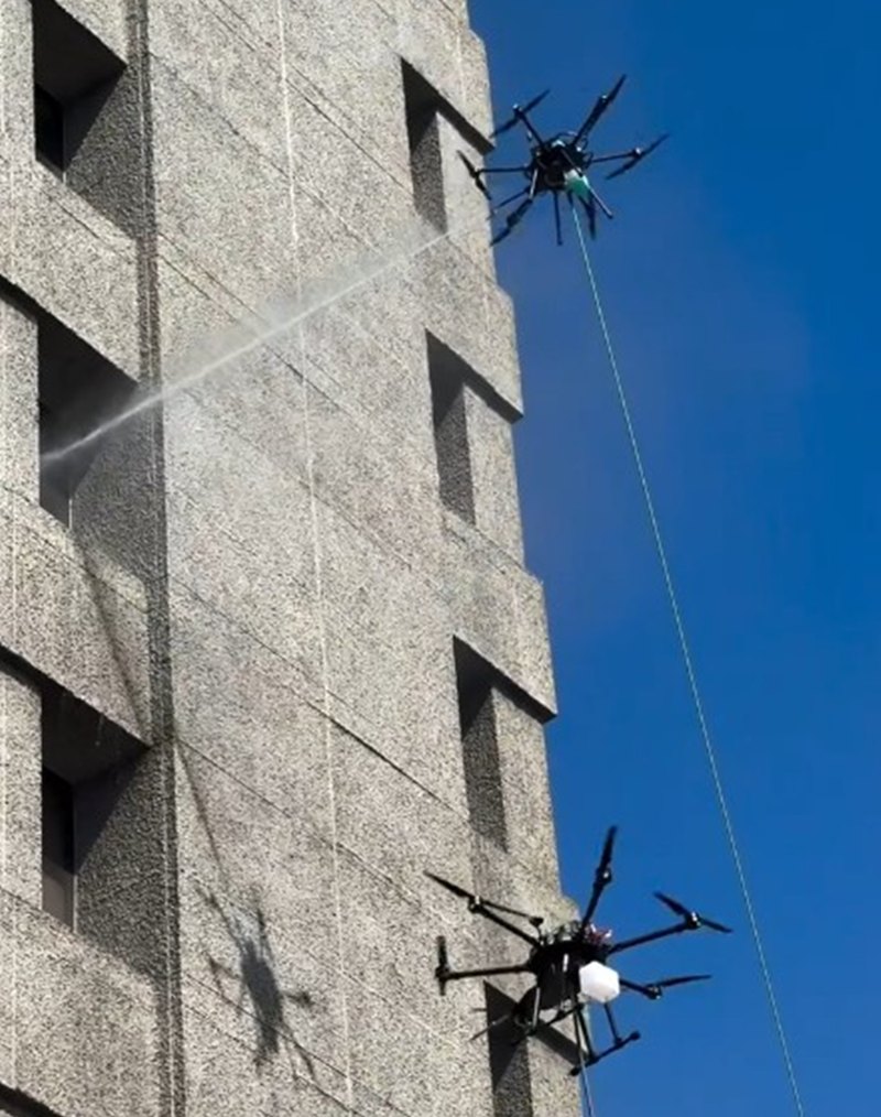 Two drones cleaning building exterior.